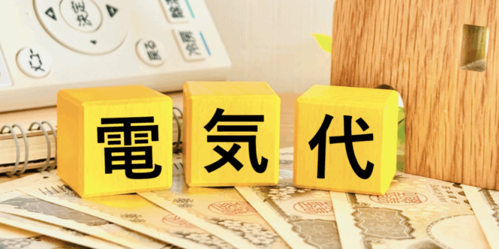 日本円紙幣の上に「電気代」と黒文字で書かれた黄色い木製ブロックが並び、節電・光熱費削減を訴求するイメージ