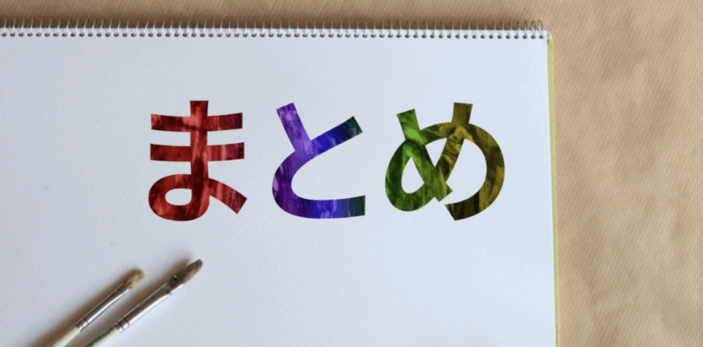 クラフト紙上に置いたスケッチブックに虹色の筆文字で「まとめ」と描かれ、そばに絵筆と絵の具チューブが置かれたクリエイティブな総括イメージ