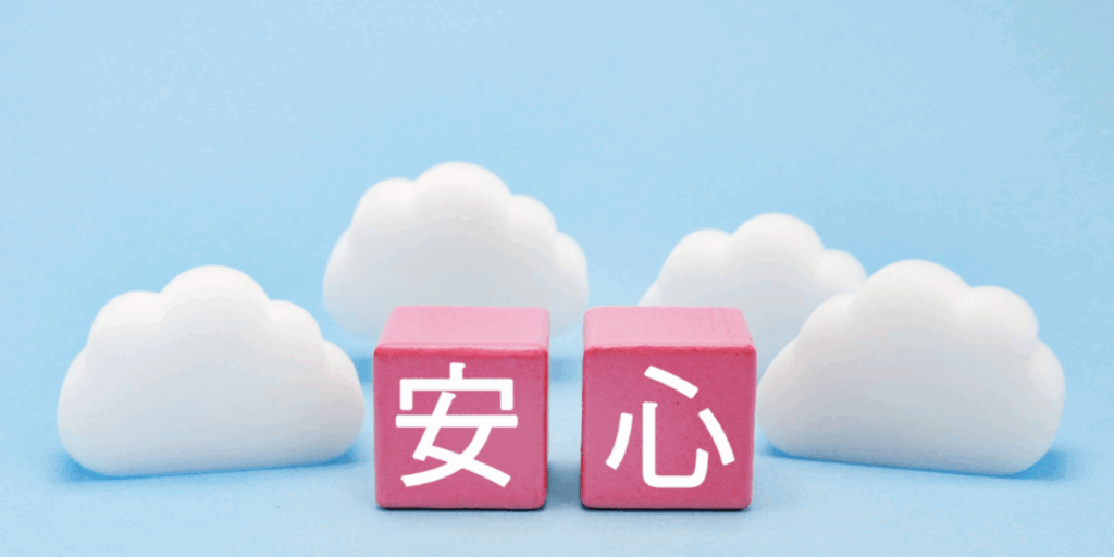 青い背景に白い雲のオブジェが並び、その前に「安心」と書かれたピンク色のブロックが2つ置かれている